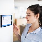 woman looking at home thermostat