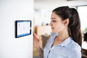 woman looking at home thermostat